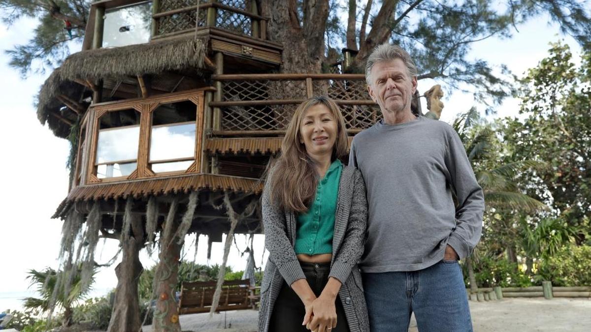 .Lynn Tran and her husband Richard Hazen pose near their Australian pine treehouse Thursday in Holmes Beach.