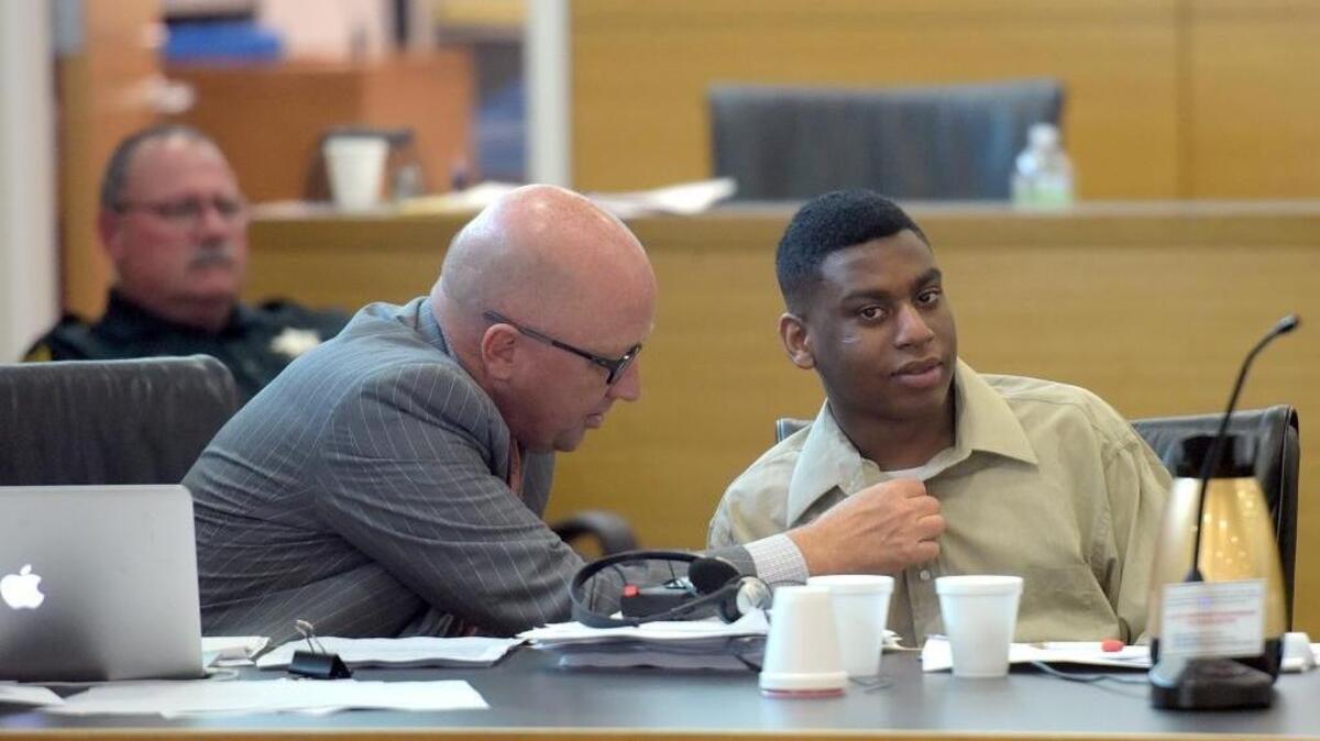 Defense attorney Bjorn Brunvand, left, adjusts a button for Trey Nonnombre, 21, Wednesday at the Manatee County Judicial Center. Nonnombre is charged with two counts of first-degree murder and armed home invasion in the July 9, 2015, fatal shootings of Esther Deneus and her boyfriend, Kantral Markeith Brooks, both 29.