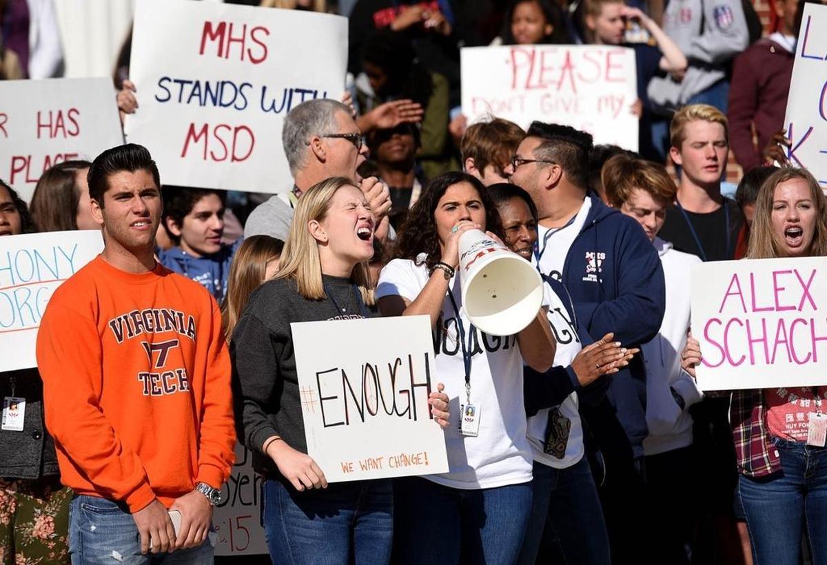 Organizers, from left, James Heagerty, Jazmin Riley and Emma Moneuse chant as Manatee High School students walk out of class on Wednesday at 10 a.m. for 17 minutes to remember those killed in the Parkland shooting.