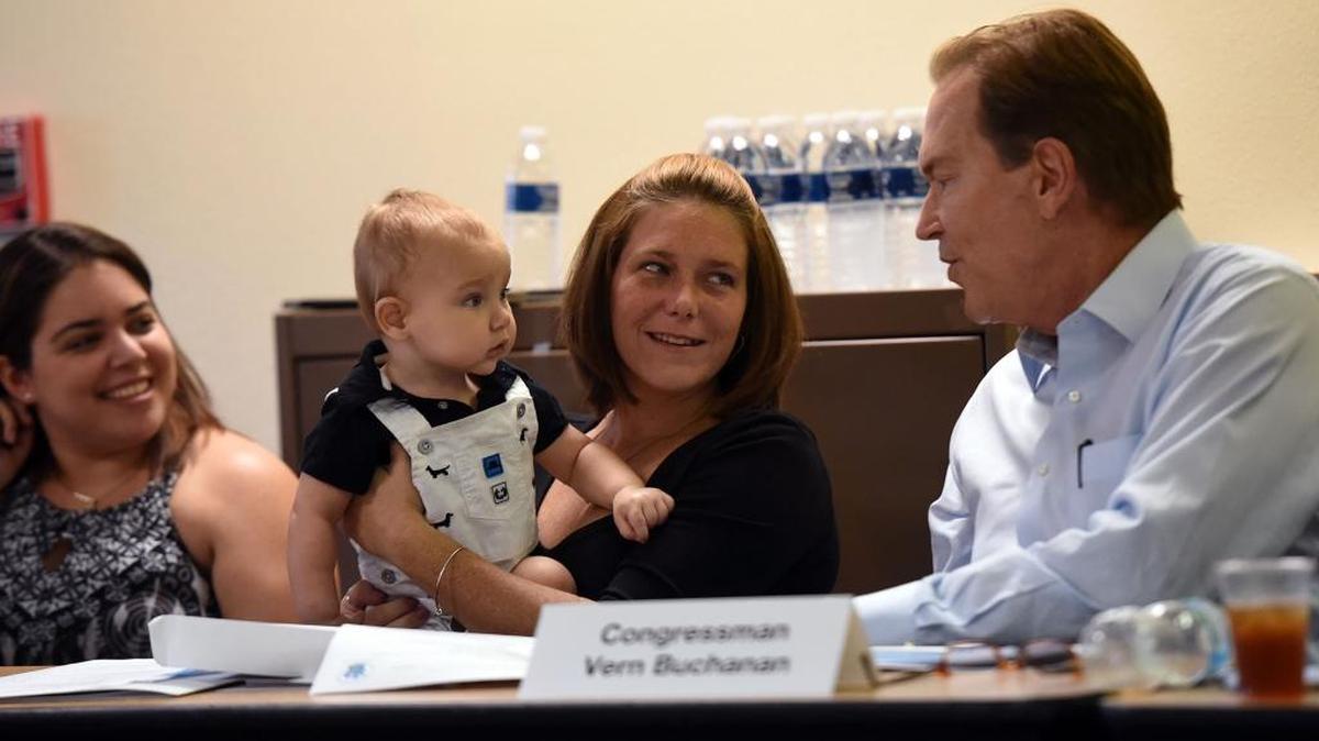 Case manager Isabella Batalla, Amber Westra with her baby, Hunter, 10 months, and Congressman Vern Buchanan as he visits the Safe Children Coalition's office on Tuesday to outline the new anti-drug law and discuss federal efforts to protect children of heroin-addicted parents.