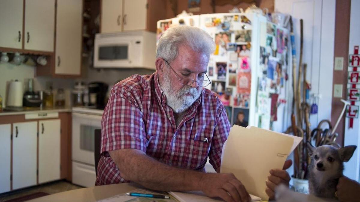 Michael Alligood goes over zoning paperwork at his home in Palmetto on Wednesday afternoon, Dec. 28, 2016. Michael Alligood has lived in the house for almost 38 years, which was built in 1926. It could be surrounded by heavy manufacturing zoning on three sides.