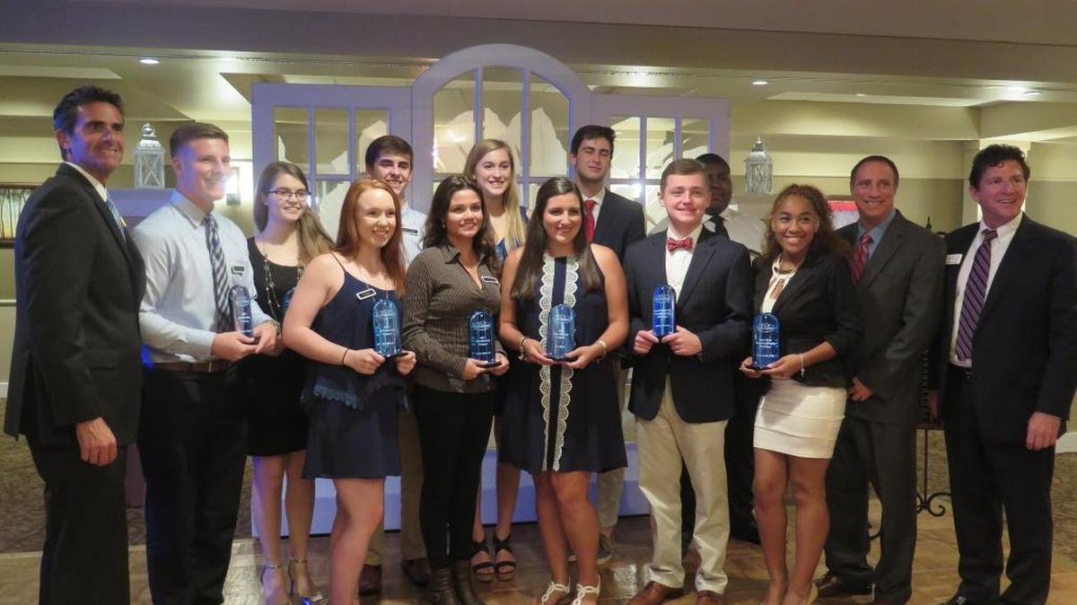 A group of recent graduates pose for photos after receiving a total of $16,000 in scholarships from the Kallins, Little, Delgado Attorneys at Law Wednesday night at the IMG Academy Golf Club.
