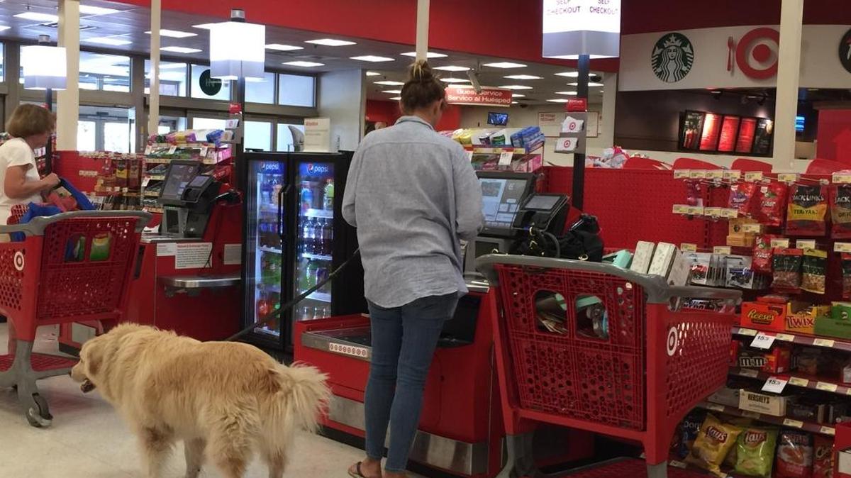 A shopper and her dog on the checkout line Jan. 1 at Target on Biscayne Boulevard in North Miami Beach.