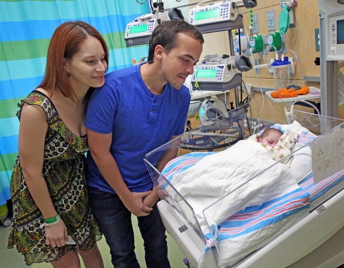 Parents Christine Silvagnoli, left, and Antonio Pieve look at their daughter, Amelia Pieve Silvagnoli, as she rests at Nicklaus Children’s Hospital in Miami on Monday, Oct. 2, 2017. Amelia is one of three infants evacuated from Puerto Rico to Miami for heart surgery after Hurricane Maria.