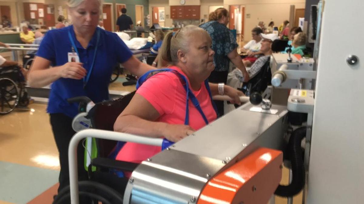 Parrish resident and stroke patient Angie Brown, right, practices walking on an AutoAmbulator while being monitored by neurological physical therapist Izabela Polivchak, left, at HealthSouth Rehabilitation Hospital of Sarasota.
