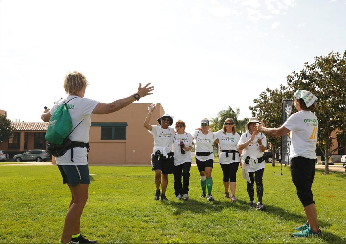 Diana Nyad, left, and Bonnie Stoll, right, welcome walkers returning from a walk with EverWalk. EverWalk aims to get Americans across the country walking.