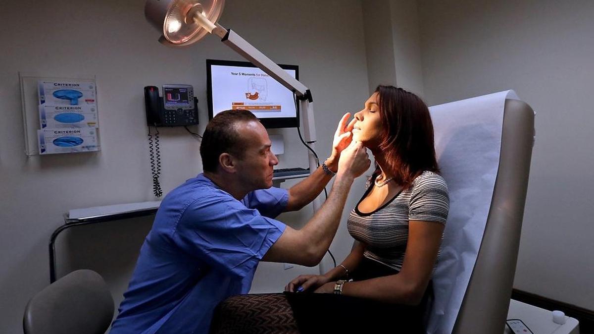Diana Guevara 28, right, gets a follow-up exam by her Plastic Surgeon Dr. Christopher Salgado during a visit to the new LGBTQ medical center at the University of Miami Miller School of Medicine on Tuesday, February 7, 2017.