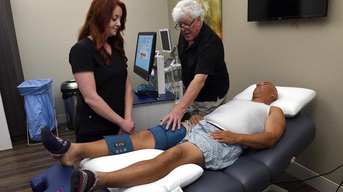 Mandy Marulanda listens as Scott MaBeth describes how ot use a “soterogram” or a “Soteria Cardiac Platform” on Bruce Bragg, which allows doctors to screen for hardening of the arteries or arterial disease, even in young people.