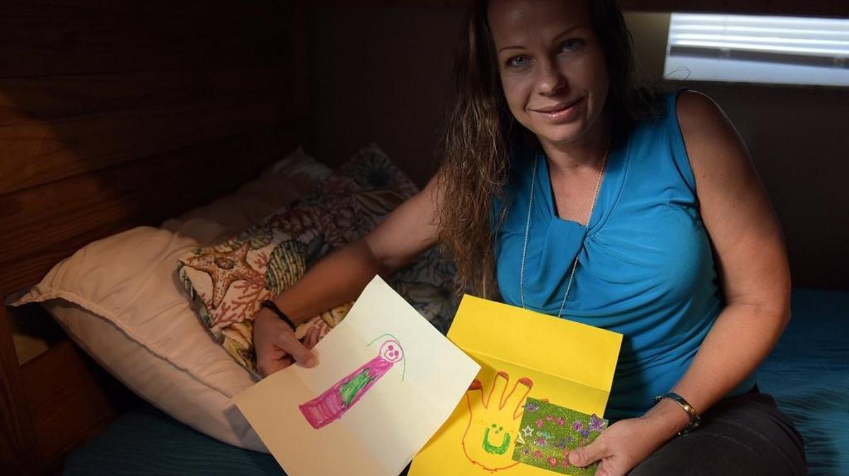 Denise Johnson, 39, holds artwork from her child as she works on recovering from heroin addiction at Beauty for Ashes.