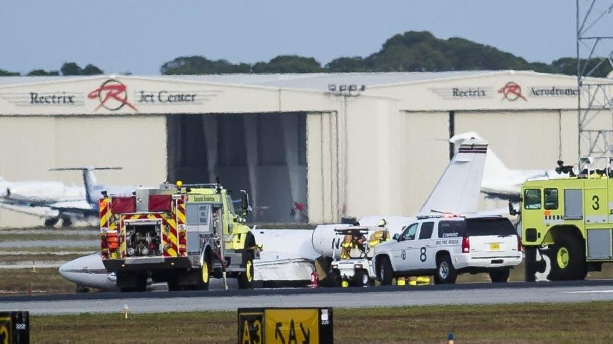 Emergency crews respond to the scene where an aircraft made an emergency landing at Sarasota-Bradenton International Airport on Friday evening. The twin-engine plane skidded into the grass after attempting to land without a left rear wheel.