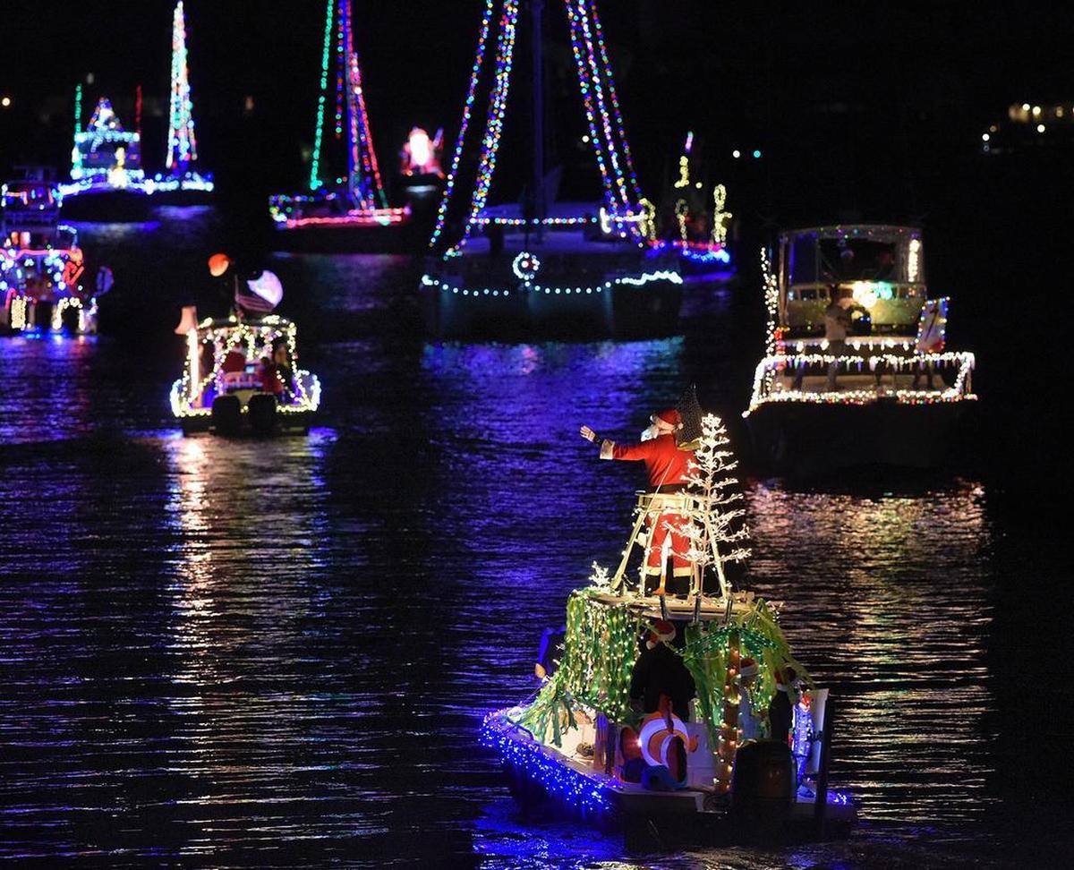 Boats glide past the Bradenton Yacht Club in Palmetto during the Manatee River Holiday Boat Parade. 