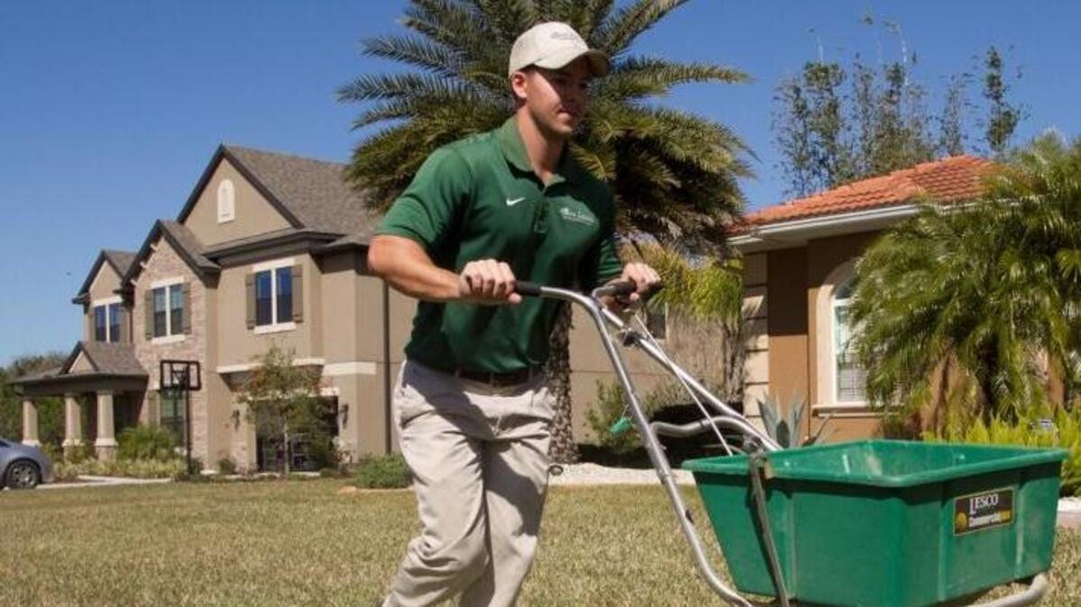 Josh Flowers, owner of Eco-Lectric Landscape Maintenance, spreads an organic fertilizer on an East Manatee lawn. Manatee County commissioners decided to keep their fertilizer ordinance that bans nitrogen fertilizer in the summer.