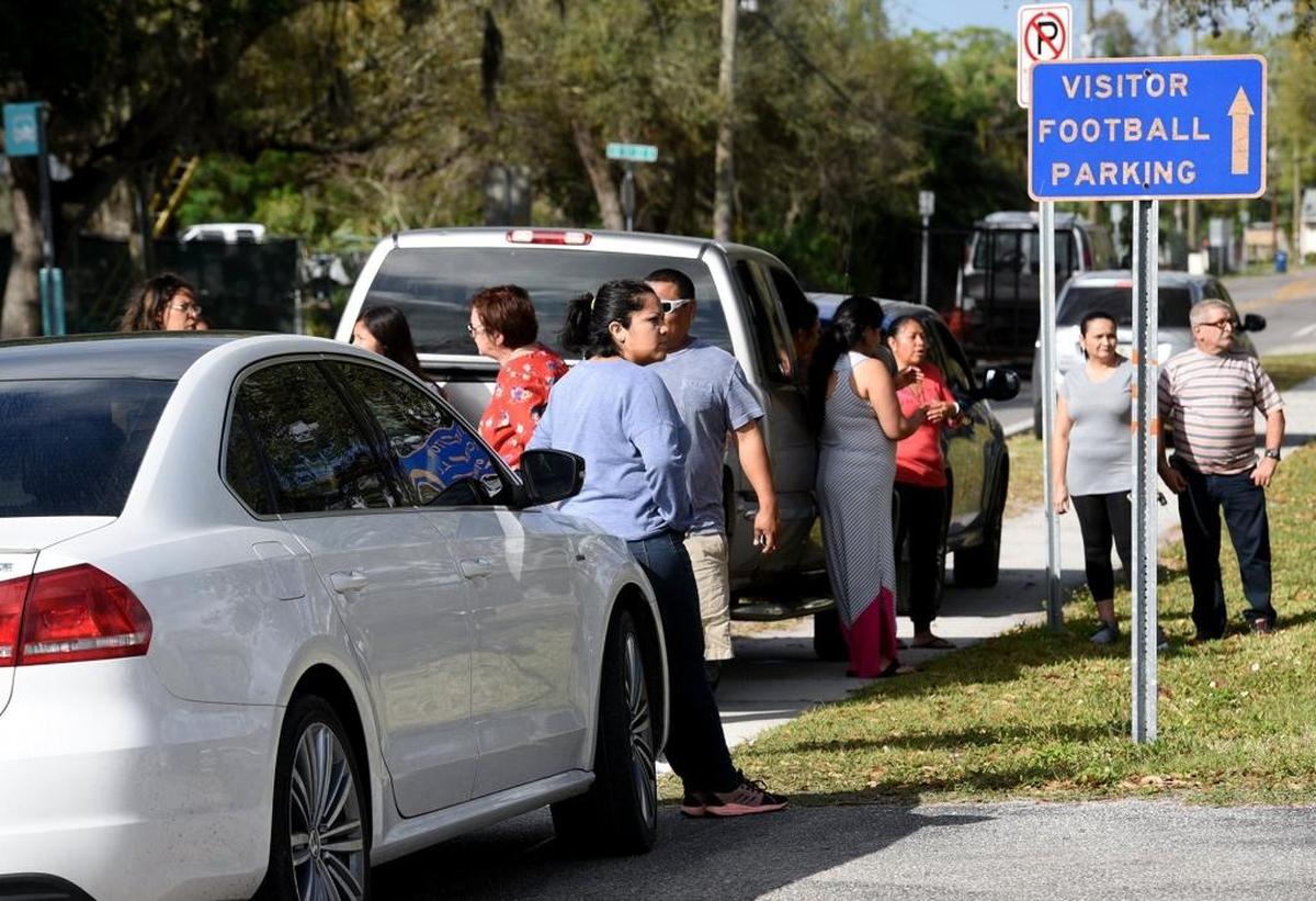 Parents wait along the street for news after a threat written on the wall of a girls restroom at Southeast High led to a lockdown for hours, keeping students in their classrooms and worried parents outside the school.