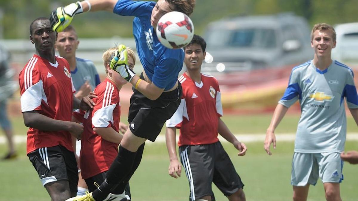 Adam Perito, a goalie for the U16 Florida Rush Soccer Team of Orlando, leaps to block a corner kick by ASG Warner of Tallahassee during the 2013 Labor Day Showcase at Premier Sports Campus in Lakewood Ranch.