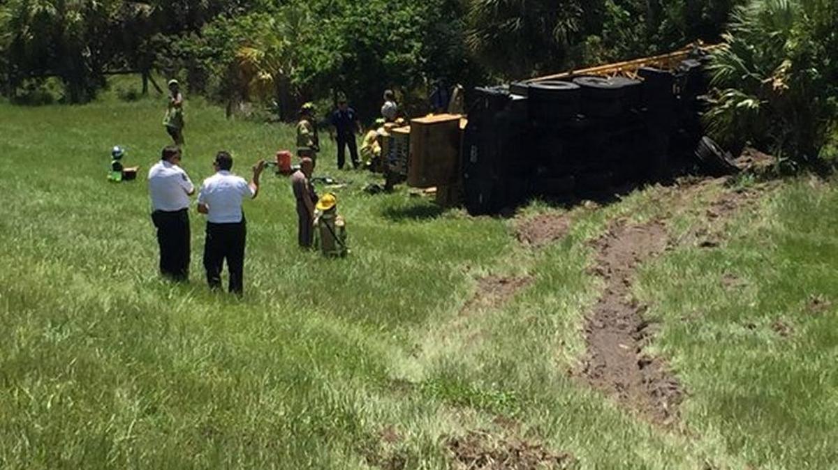 A crane lays on its side in the ditch off Interstate 75 at mile marker 228 after it flipped over and crashed, killing the man driving.
