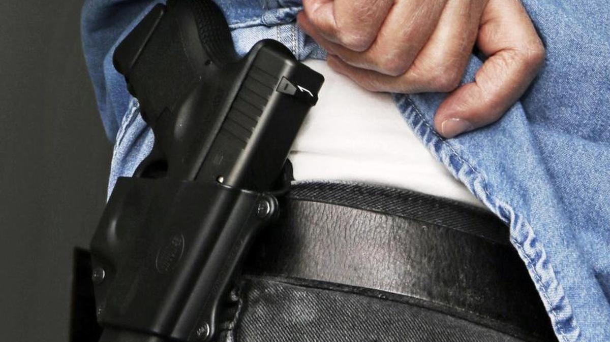 In this Feb. 27, 2013 file photo Hank Johnson displays his handgun, in Springboro, Ohio.