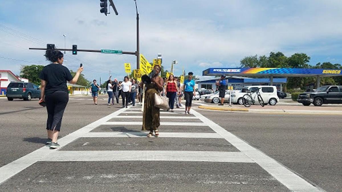 Darnesha McMillan leads protestors across North Washington Boulevard at the intersection with Dr. Martin Luther King Jr. Way after she says her fiance was assaulted by Sarasota police during his arrest Thursday evening.