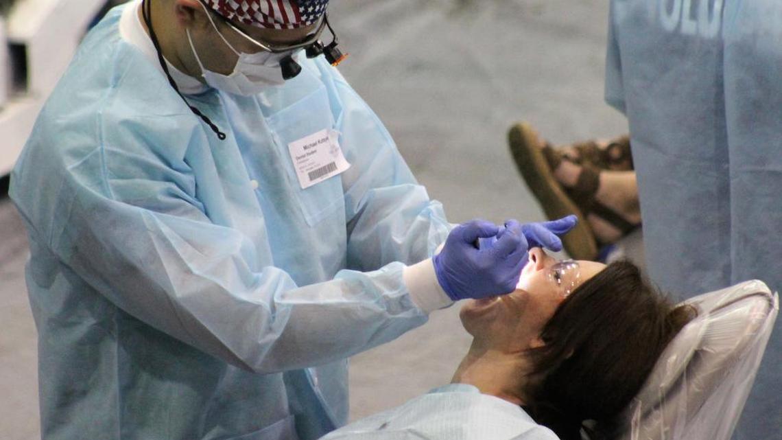A volunteer dentist examines a patient at a recent Remote Area Medical clinic. RAM is coming back to Manatee County Nov. 11-13.