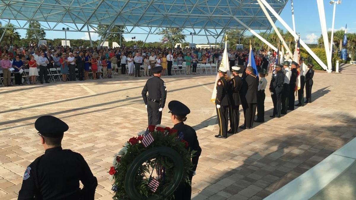 The crowd at Patriot Plaza stands as a combined honor guard of Sarasota fire, police, sheriff's office and Elks post the colors at Patriot Plaza at the start of the 9/11 15th year Commemoration.