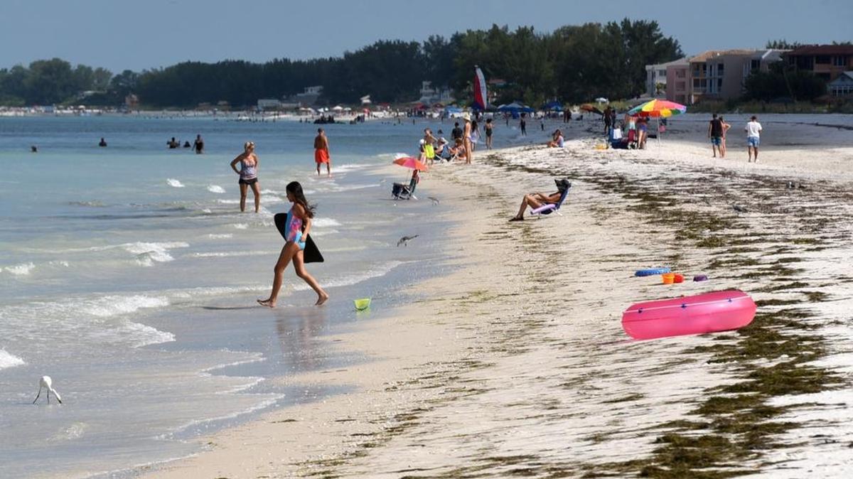 Small waves lap the beach as people enjoy the weather at Bradenton Beach in July 2016.