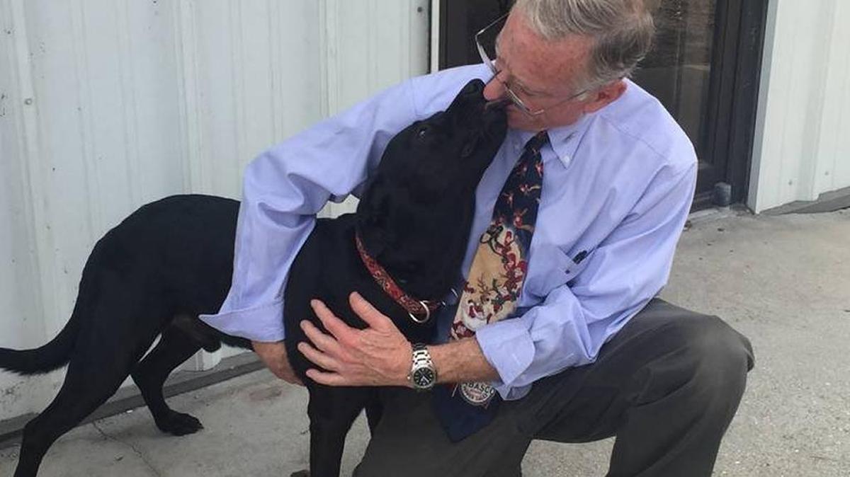 In this file photo, Dr. Paul Gartenberg hugs his black Labrador mix, Padi, after a judge ruled a Florida dangerous dog law unconstitutional. Legislation inspired by Padi’s predicament was later signed and the dog’s story appeared in the Florida Bar Journal.