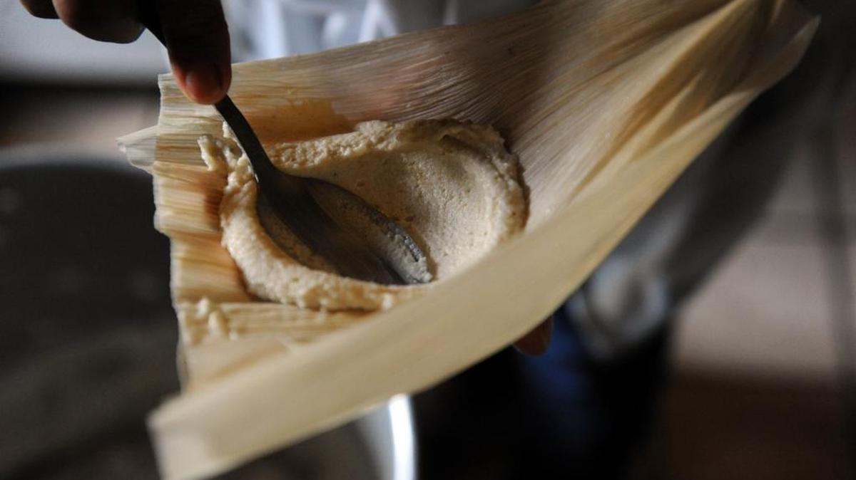 Juanita Hernandez, originally from Mexico, cooks her tamales in her Bradenton home. Here she puts the masa into the tamale after mixing it by hand to the perfect consistency.
