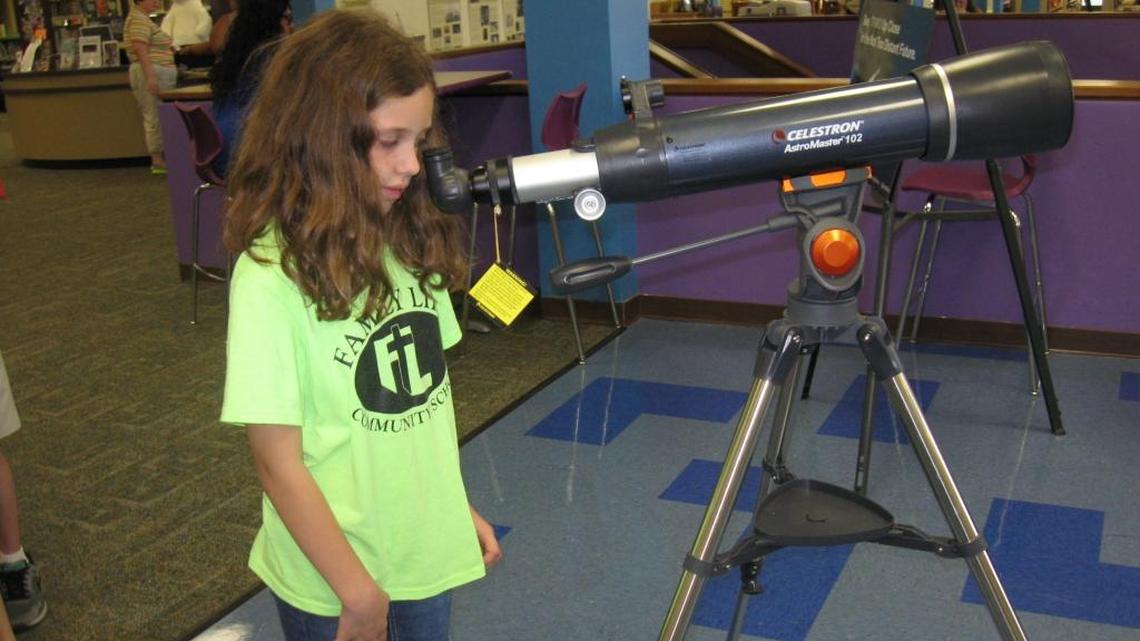 Emma Sietsma, 9, checks out one of the display telescopes on on the third floor of the Manatee County Central Library on Wednesday, Dec. 7, 2016. The library has ordered 13 telescopes and 13 pairs of binoculars, and will be lending them out.