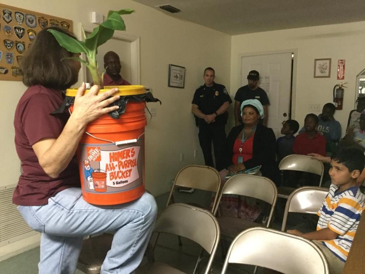 The University of Florida’s Lisa Hickey, urban horticulture/master gardener coordinator, teaches a handful of Washington Park residents about the extension office’s “plant in a pale” program well suited for the urban gardener.