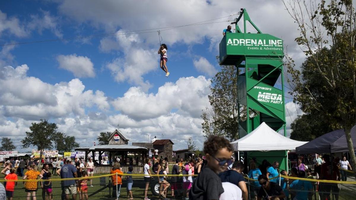 Children fly down the zip line during the Husander Farms 26th annual Pumpkin Festival in East Manatee.