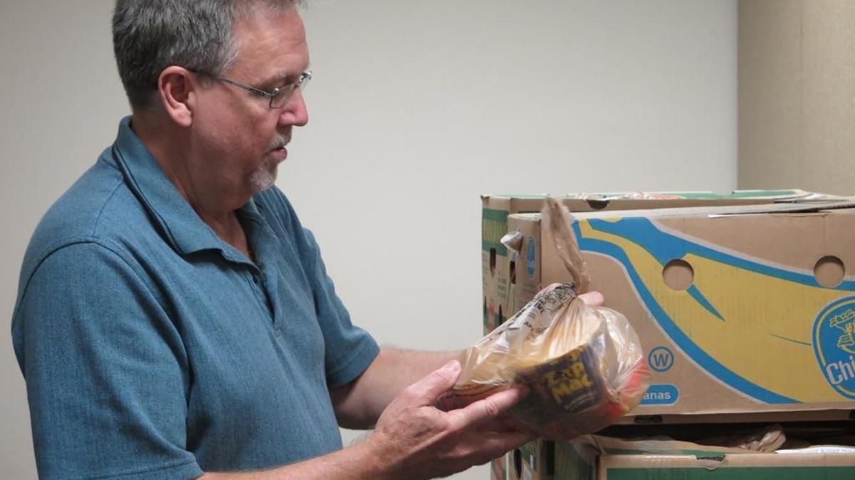 Kevin Beach, Manatee County’s library operations manager, goes through the boxes of food at the Central Library for children in need of meals over the weekend.