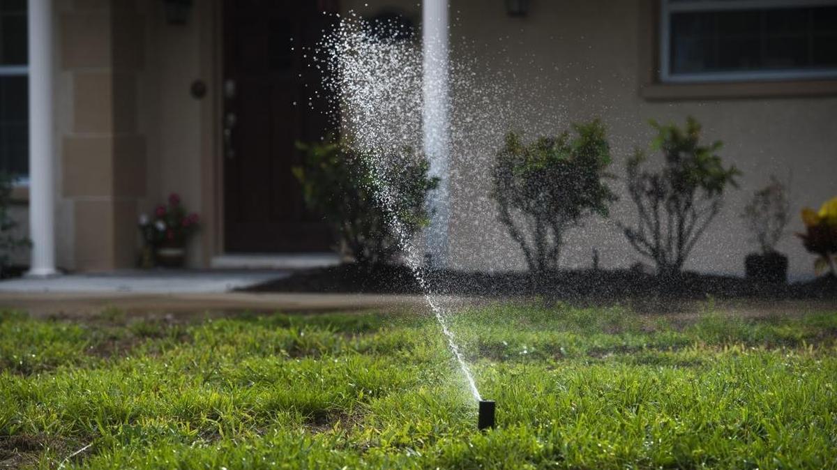 Sprinklers spray water across residential lawns in West Bradenton.