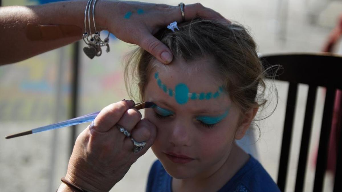Hailey Penix of Lithia gets her face painted Saturday at one of the booths set up for the Christmas on Bridge Street event on Anna Maria Island.
