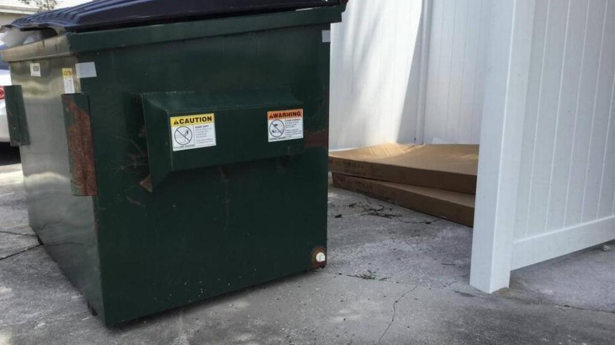 Firefighters had to rescue a man trapped on top of a garbage truck Thursday after deputies say the truck lifted a dumpster with him inside.