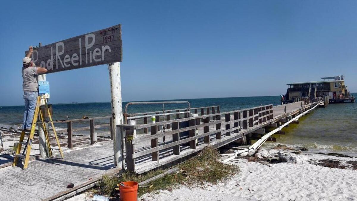 Fred Wilson, a resident of the island since 1970, works on replacing a light on the Rod & Reel Pier which has reopened since Hurricane Irma Wednesday on Anna Maria Island.