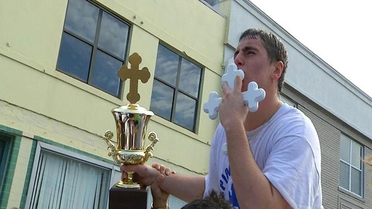 Christian Chrysakis, 18, kisses the cross that he retrieved Saturday afternoon from Spring Bayou in Tarpon Springs.