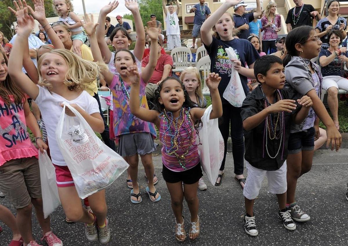 Children shout for beads during a past De Soto Grand Parade.