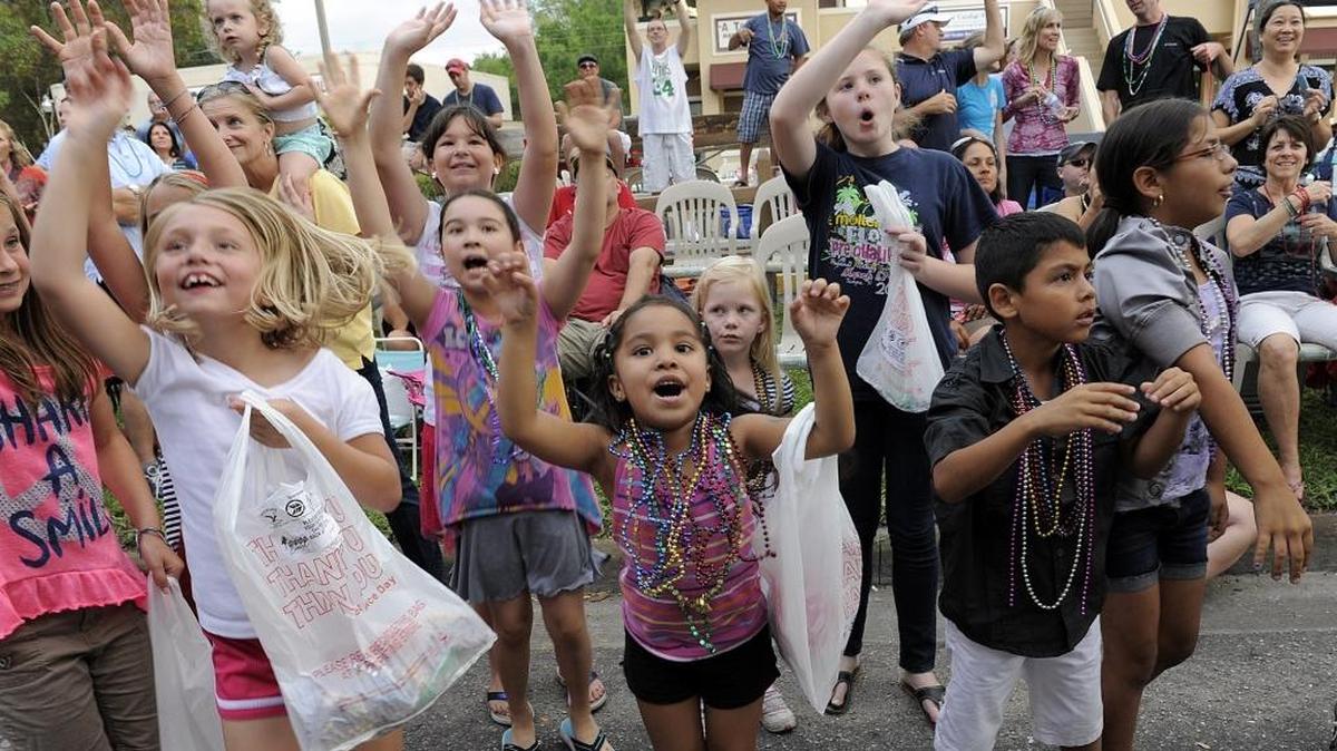 Children shout for beads during a past De Soto Grand Parade.