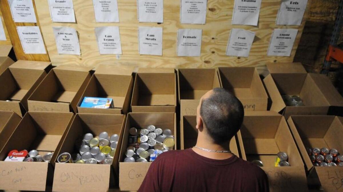 Warehouse assistant Michael Donofrio sorts through the small amount of donated dry goods available at the Manatee County Food Bank in this file photo.