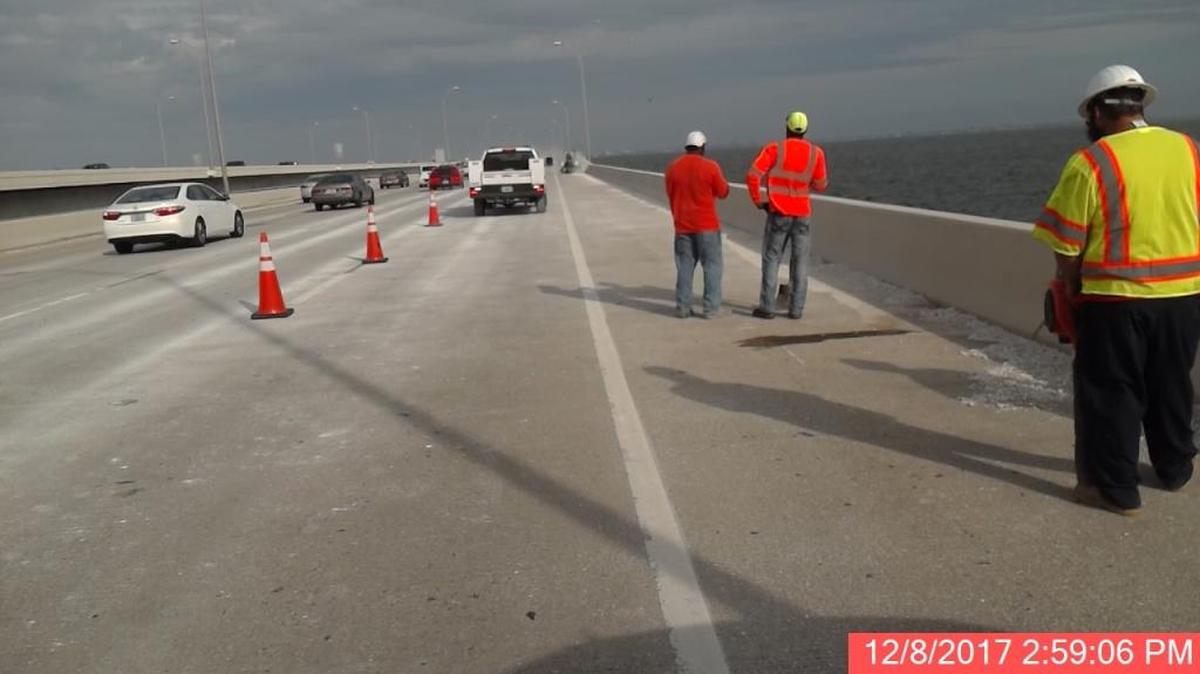 Crews work to clean gravel spilled onto the Howard Frankland by an unknown vehicle Friday afternoon.