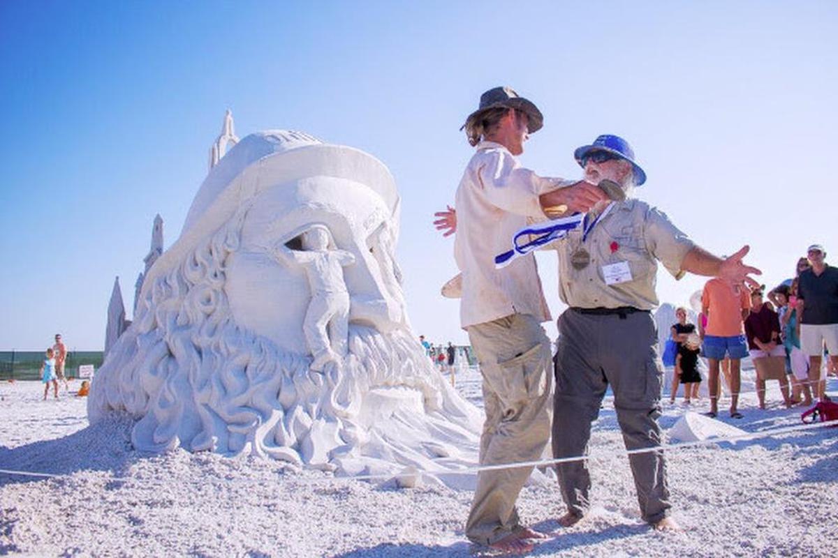 Sculptors Abram Waterman (left) and Walter MacDonald celebrate winning first prize at the 2016 Siesta Key Crystal Classic International Sand Sculpting Festival on Siesta Beach.