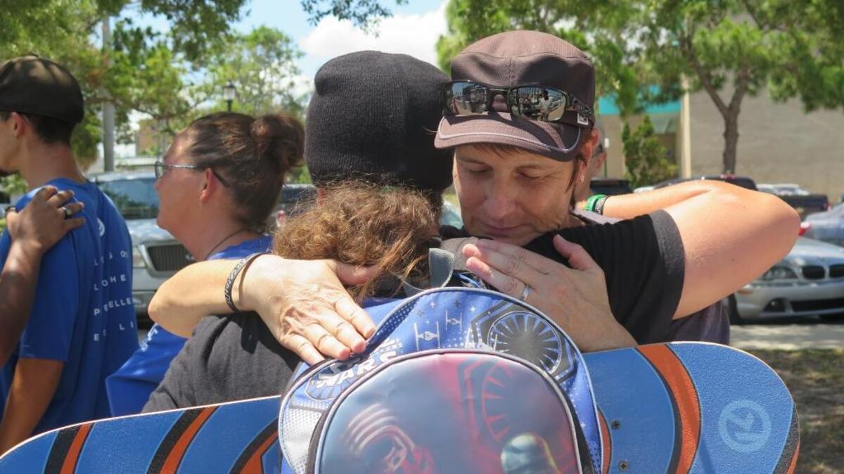 Christine Monroe-Loomes, with DOWNTOWN Ministries, hugs someone after handing out a lunch on Bradenton Riverwalk on Wednesday.