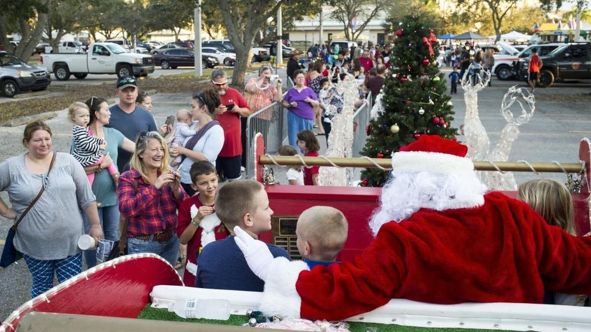 A line stretches around the parking lot as hundreds of families wait for their chance to take a photo with Santa Claus during the “A Night Before Christmas” celebration on Saturday evening at G.T. Bray Park in Bradenton.