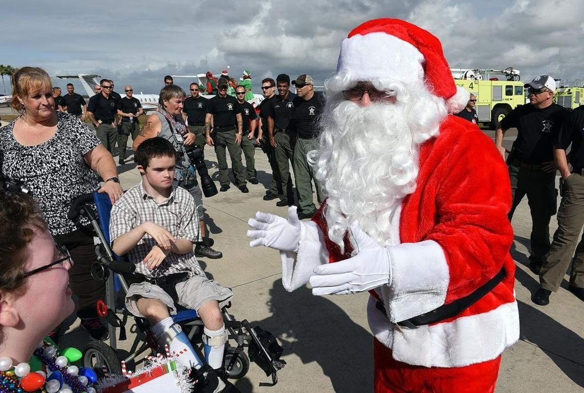 Santa greets children at the annual Flight to the North Pole Christmas celebration for children with illnesses, hosted by the Manatee County Sheriff's Office, Thursday at the Sarasota/Bradenton Airport Fire Station.