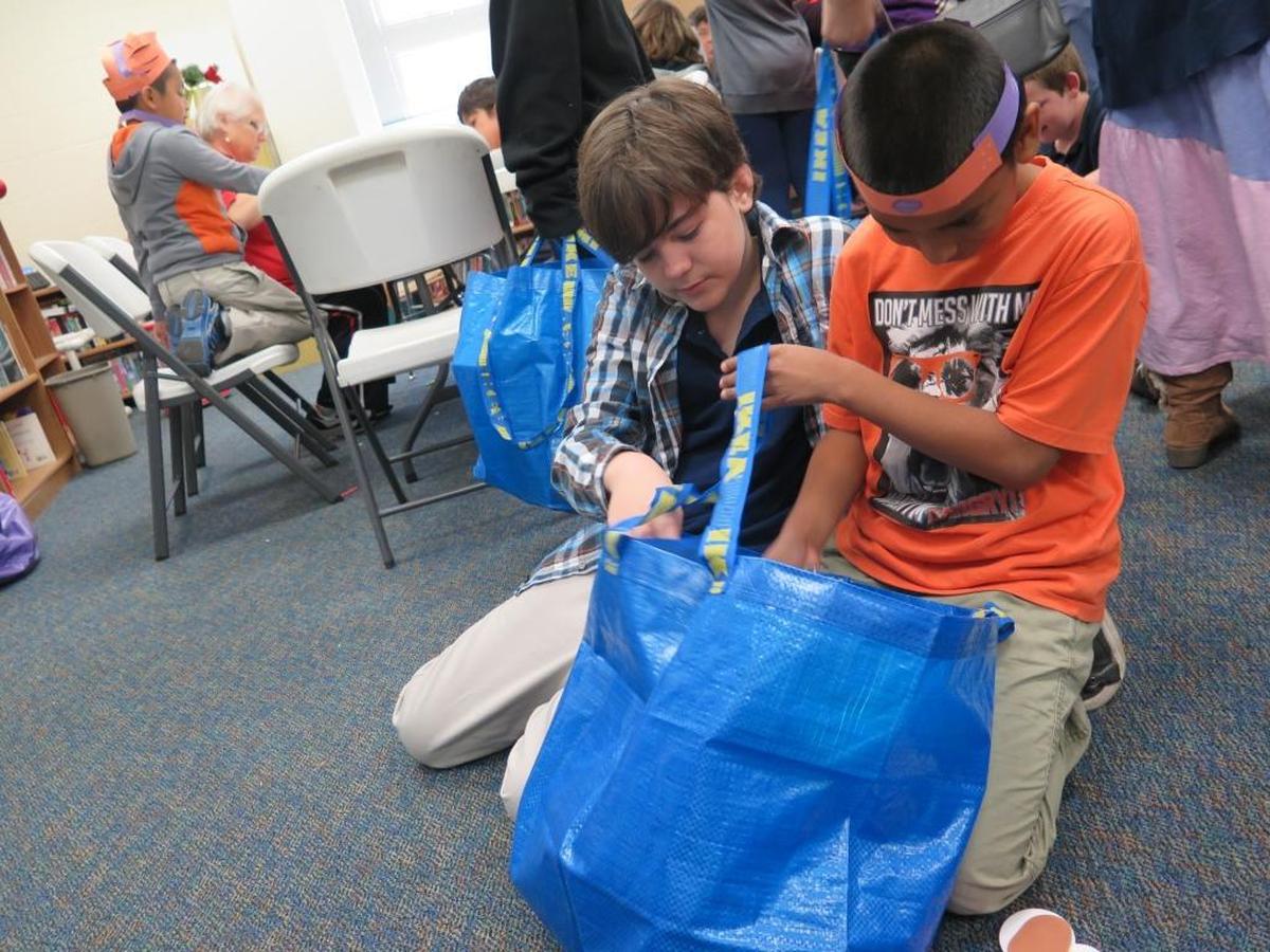 McKay Academy students look through a bag full of gifts from Santa Claus after a visit from the Flight to the North Pole program Friday.