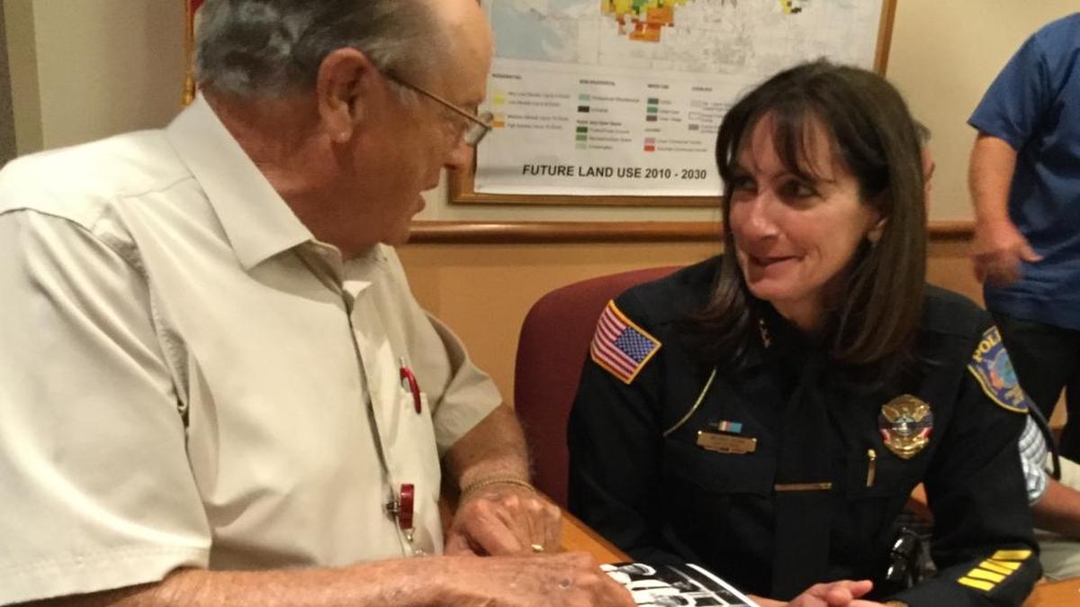 Bradenton City Councilman Gene Gallo and Police Chief Melanie Bevan discuss an old photo of BPD officer Carl Cox, who was killed while on duty in 1970. Cox is on the National Police Memorial in Washington D.C., but another BPD officer who died on duty in 1934 is not on that wall. Bevan hopes to rectify that soon.