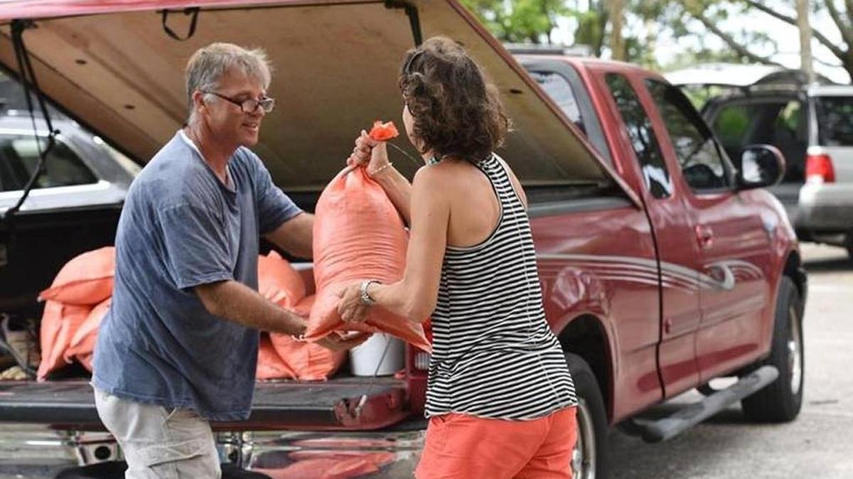 Todd Fleck and Gretchen Leclezio load up sandbags at G.T. Bray as people anticipate more rain Monday after a weekend of weather caused widespread flooding in Manatee County.