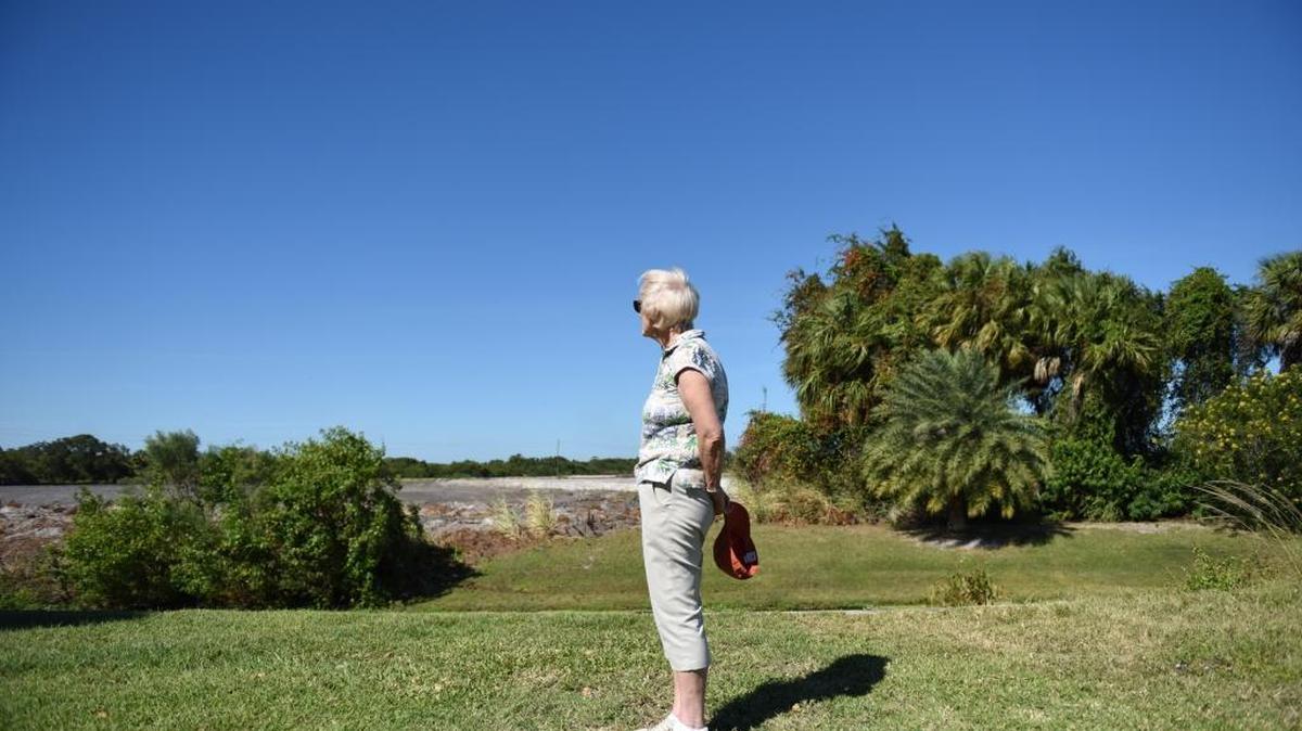 Arlene Dukanauskas, resident of Legends Bay, stands in her neighbor’s backyard in front of the spot where, on the other side of the creek, was a “landmark” pine tree. On Oct. 17, Medallion Homes, Inc. bulldozers knocked down a sizeable chunk of a conservation area on Legends Bay land.