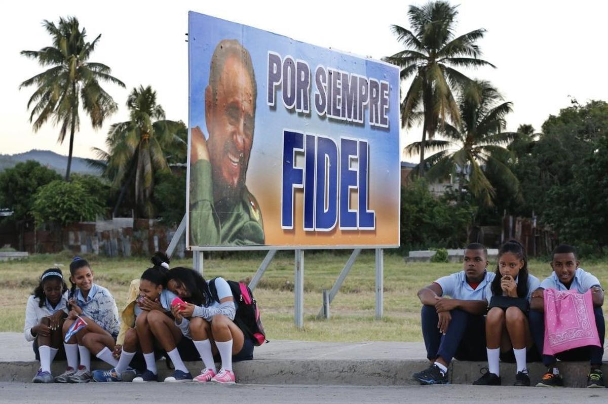 Children wait for the arrival of the caravan carrying the ashes of Fidel Castro on the road to Cemeterio Santa Ifigenia in Santiago de Cuba on Sunday, December 4, 2016.