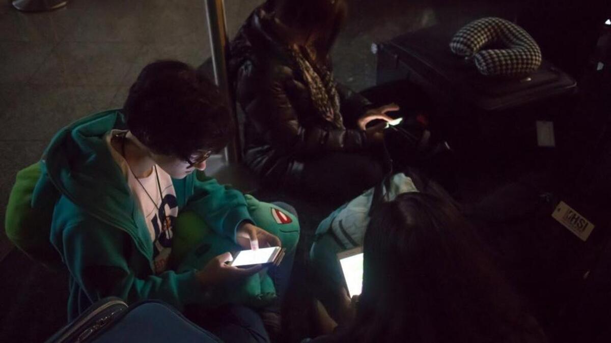 Isabelle Jacobs waits for her flight to New York in a dark terminal at Hartsfield-Jackson International Airport on Sunday. The airport reported a loss of electricity. The FlightAware site reported the airport was holding all inbound flights due to an equipment outage.