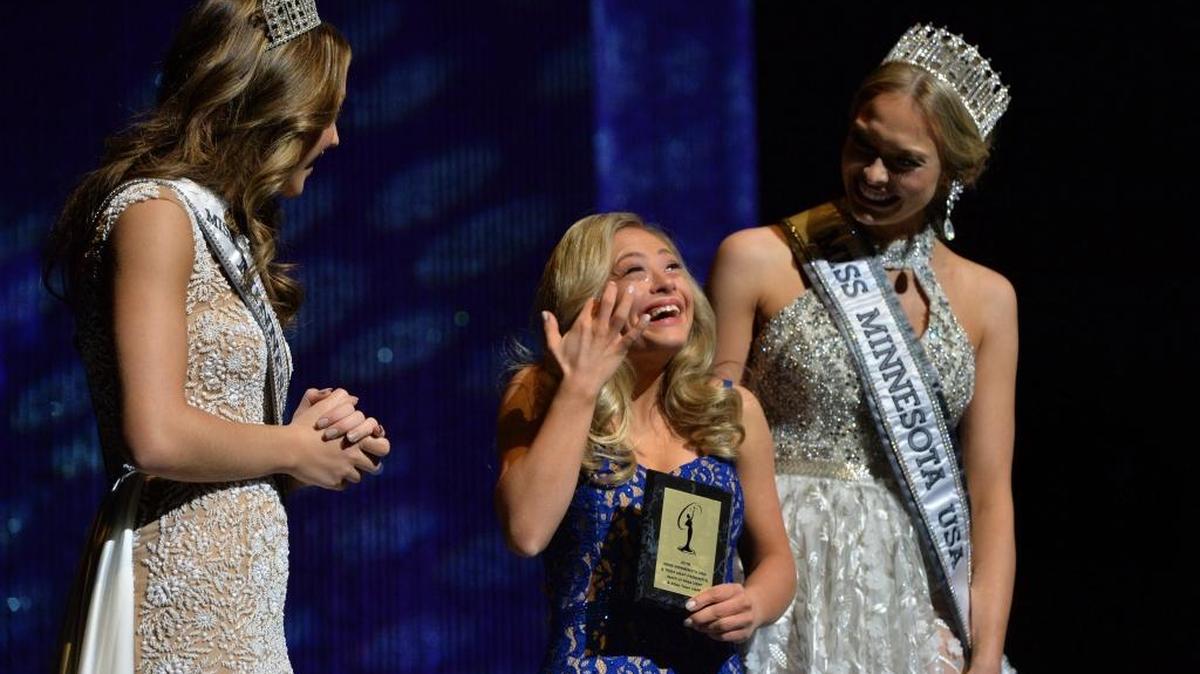 Mikayla Holmgren, center, accepts the “Spirit Award” during the 2018 Miss Minnesota USA contest on Sunday. Holmgren, 22, made history by becoming the first woman with Down syndrome to compete in the Miss Minnesota USA pageant. Holmgren, who also is believed to be the first woman with Down syndrome to compete nationwide, was named the recipient of the Miss Minnesota USA Spirit Award and Director’s Award.